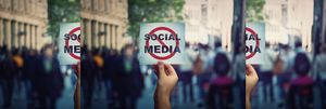 Image of a hand holding up a sign that reads social media with a red ircle and strike through line over the words.